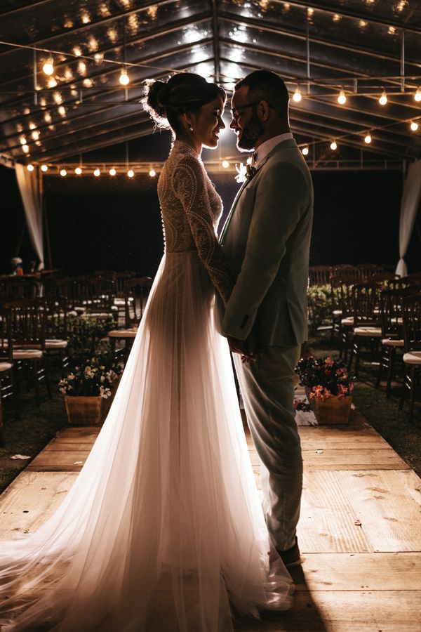 Newlyweds beneath glowing reception lights